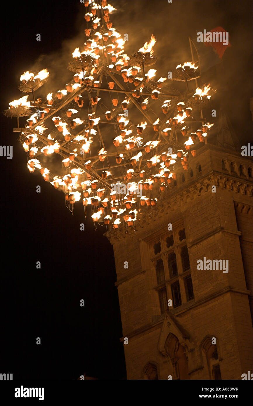 Large wooden chandelier lit by ceramic fire pots hanging against black night sky, [Luminox Fire Festival], Oxford, England, UK Stock Photo