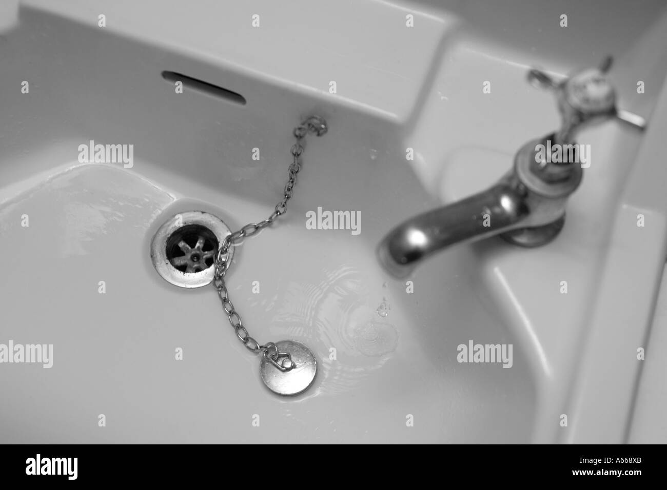 old bathroom sink with tap running Stock Photo Alamy