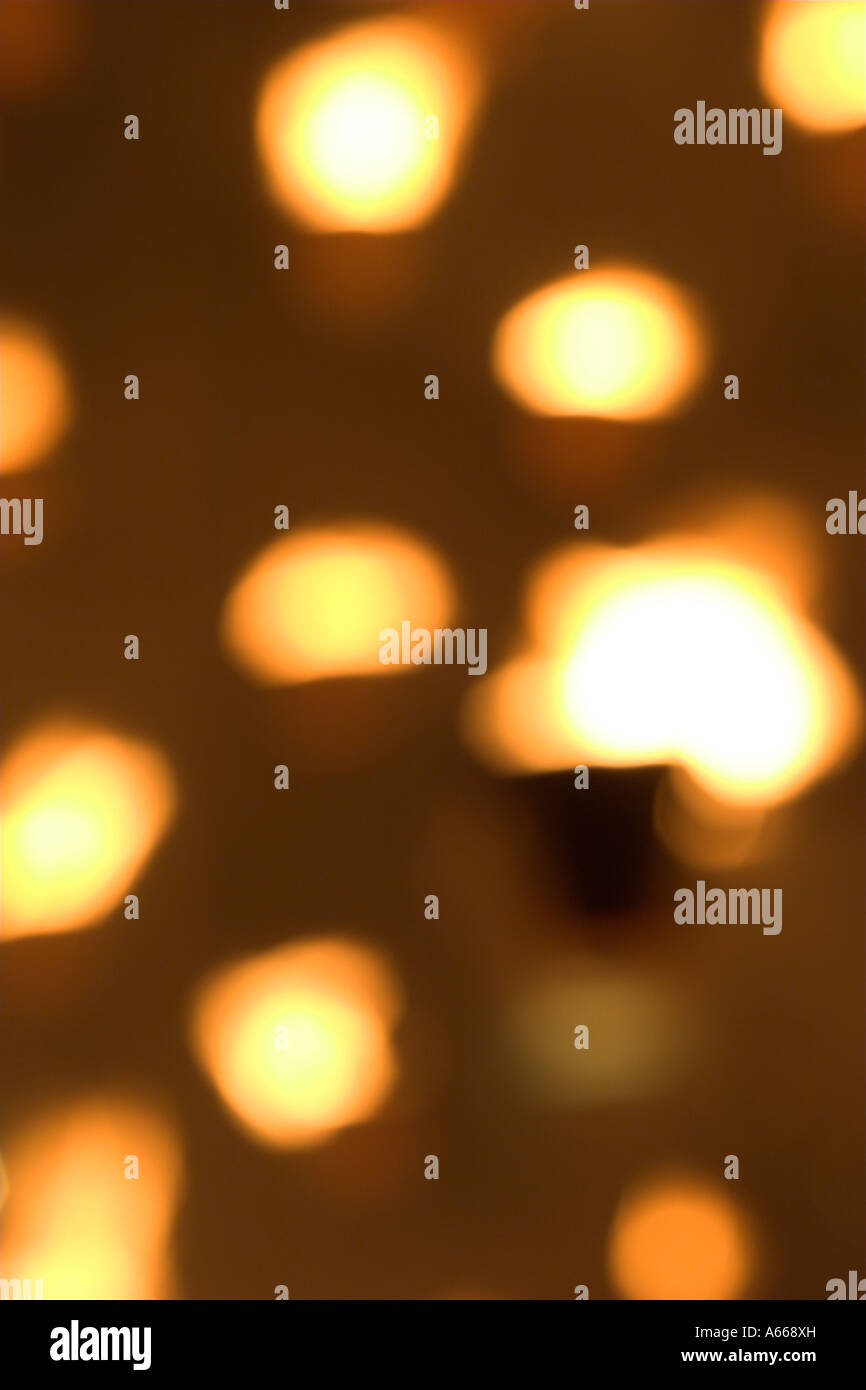 Beautiful orange and yellow 'out of focus' candlelight glowing at night against [dark background], abstract light pattern Stock Photo