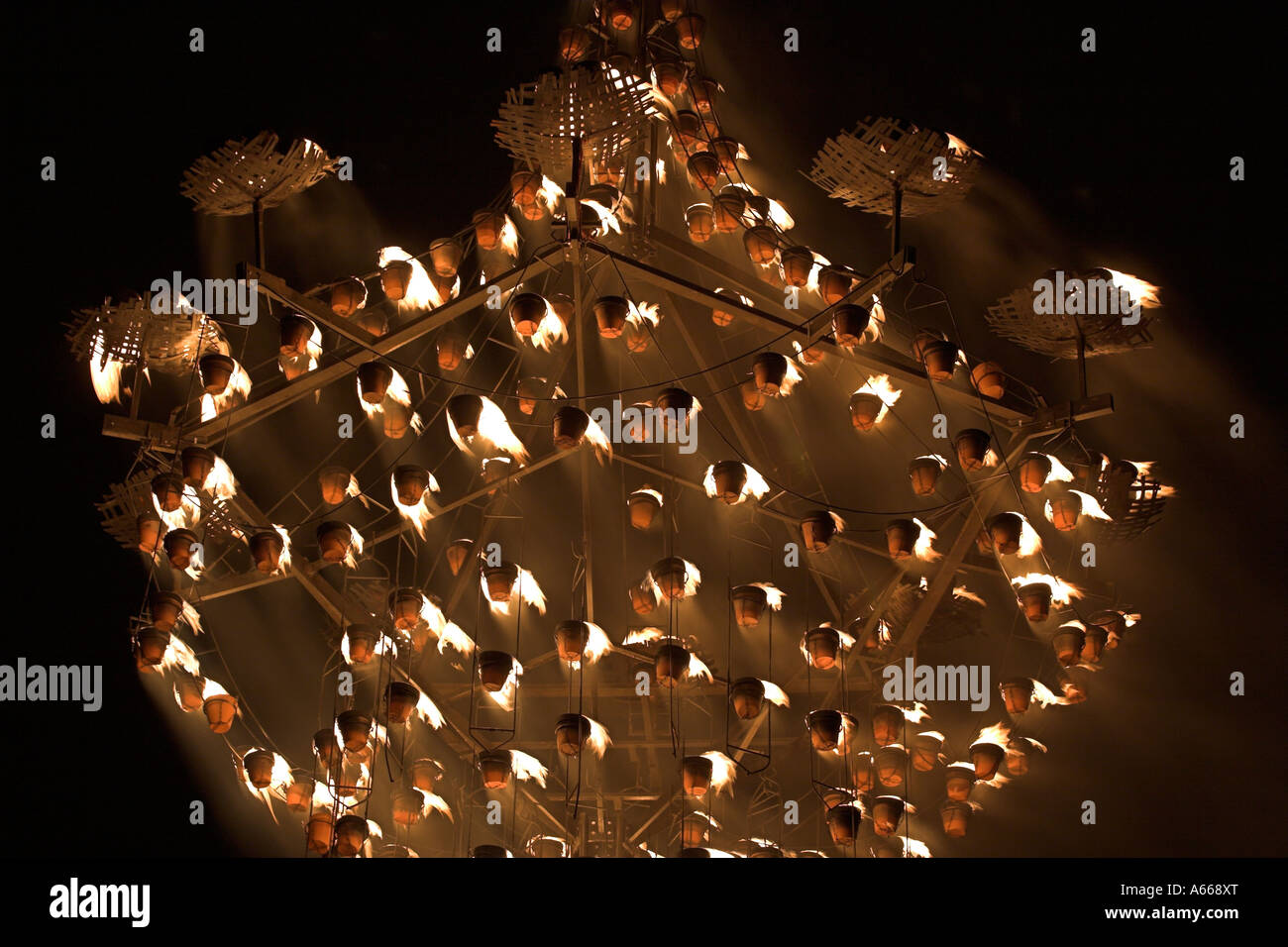 Large wooden chandelier lit by ceramic fire pots against black night sky, [Luminox Fire Festival], Oxford, England, UK Stock Photo
