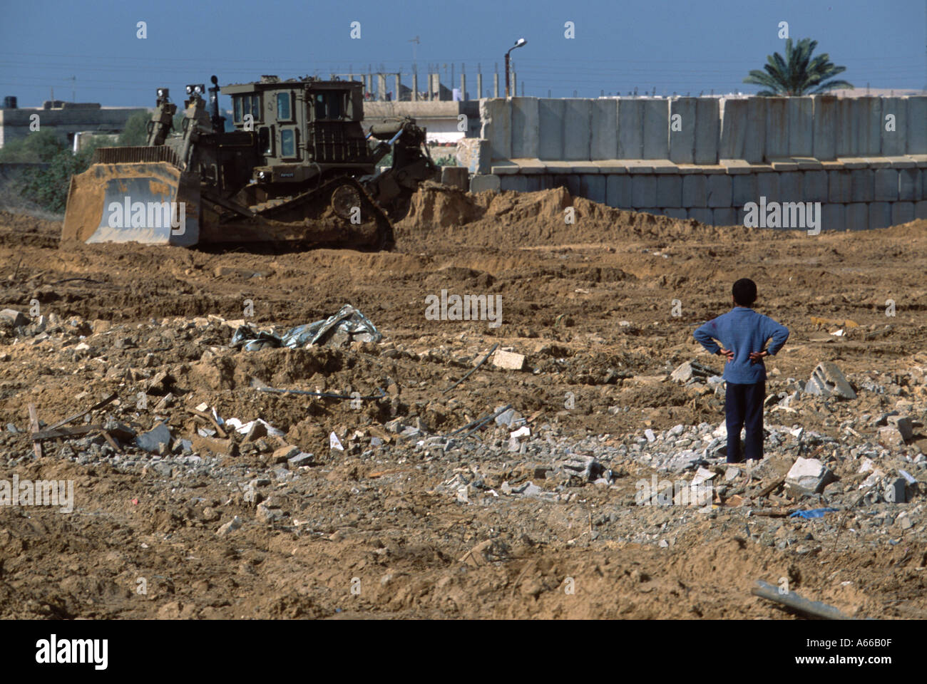 Palestinian boy looking at Israeli bulldozer in action Rafah Palestine Stock Photo