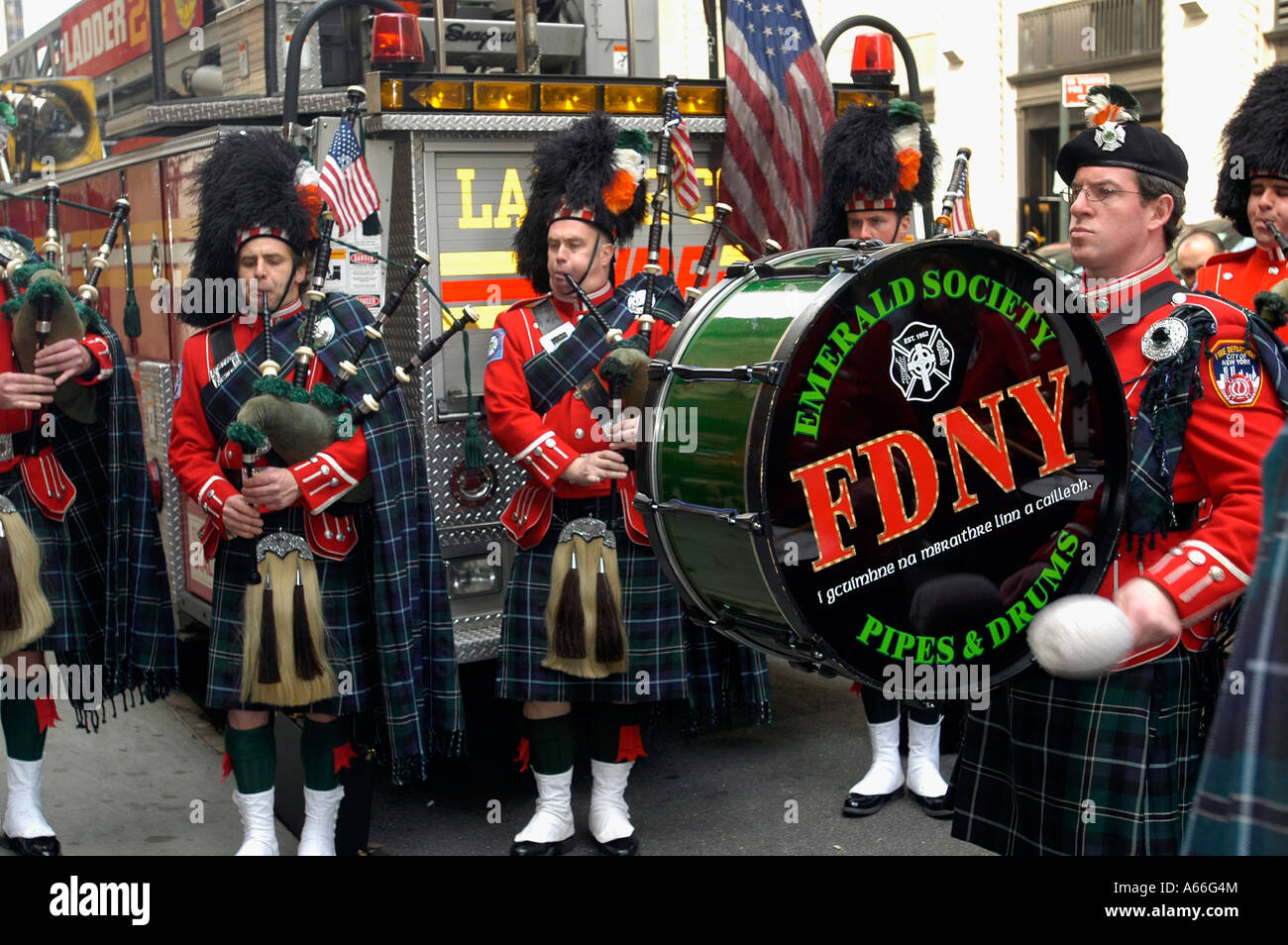 The FDNY Emerald Society Pipes and Drums performs outside the quarters of Engine Co 1 and Ladder Co 24 in NYC Stock Photo