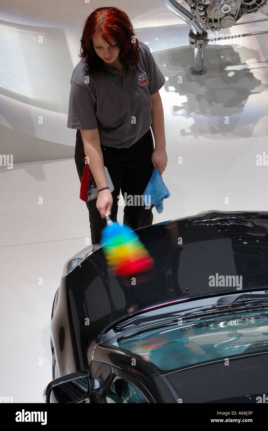 A car cleaner at the Geneva Motor Show. Motion blur on her duster. Stock Photo
