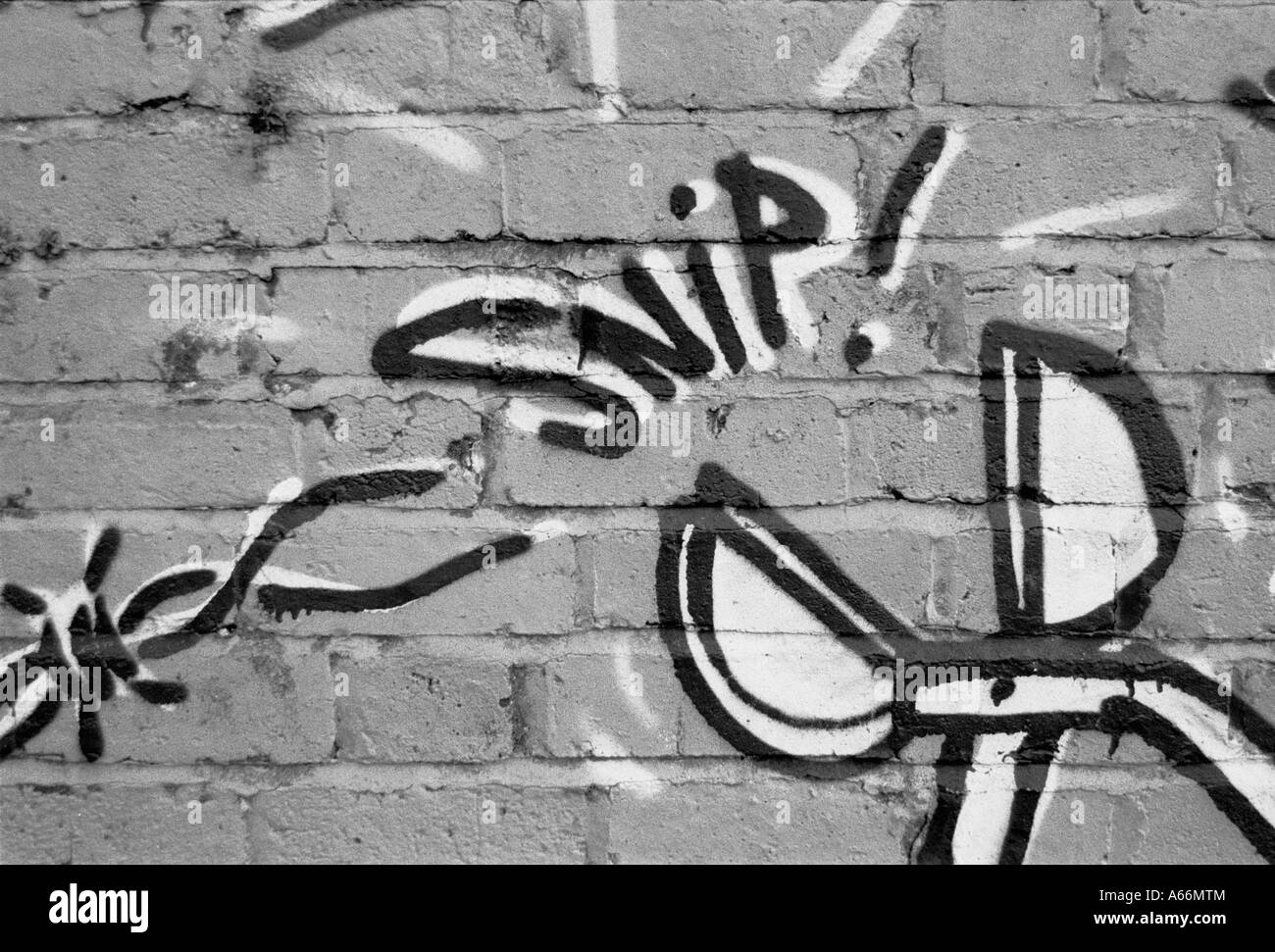 Wire cutters snip through barbed wire, black & white image of a graffiti mural, Meadow Lane, Oxford, UK 2004 Stock Photo