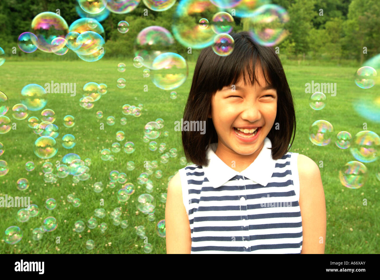 9 year old playing with bubbles MR in a grassy park Maryland Stock