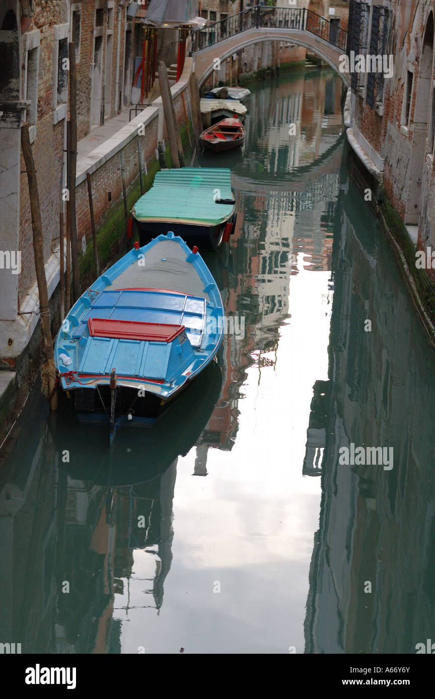 Venetian canal with wooden boats and the reflection of houses on the ...