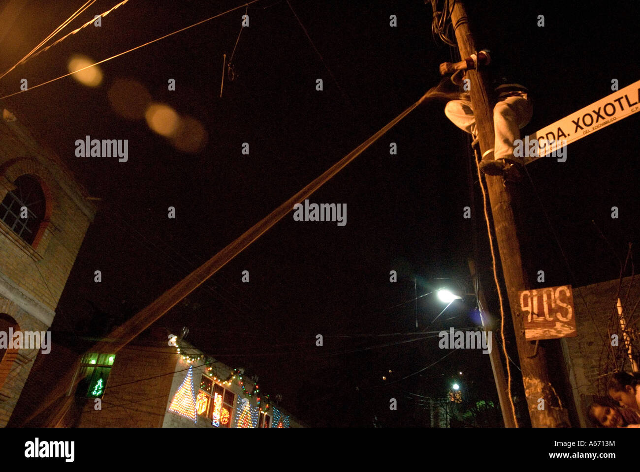 man climb a pole and hold a rope - breaking the pinata - posada, the  christmas game at night - mexico city Stock Photo - Alamy