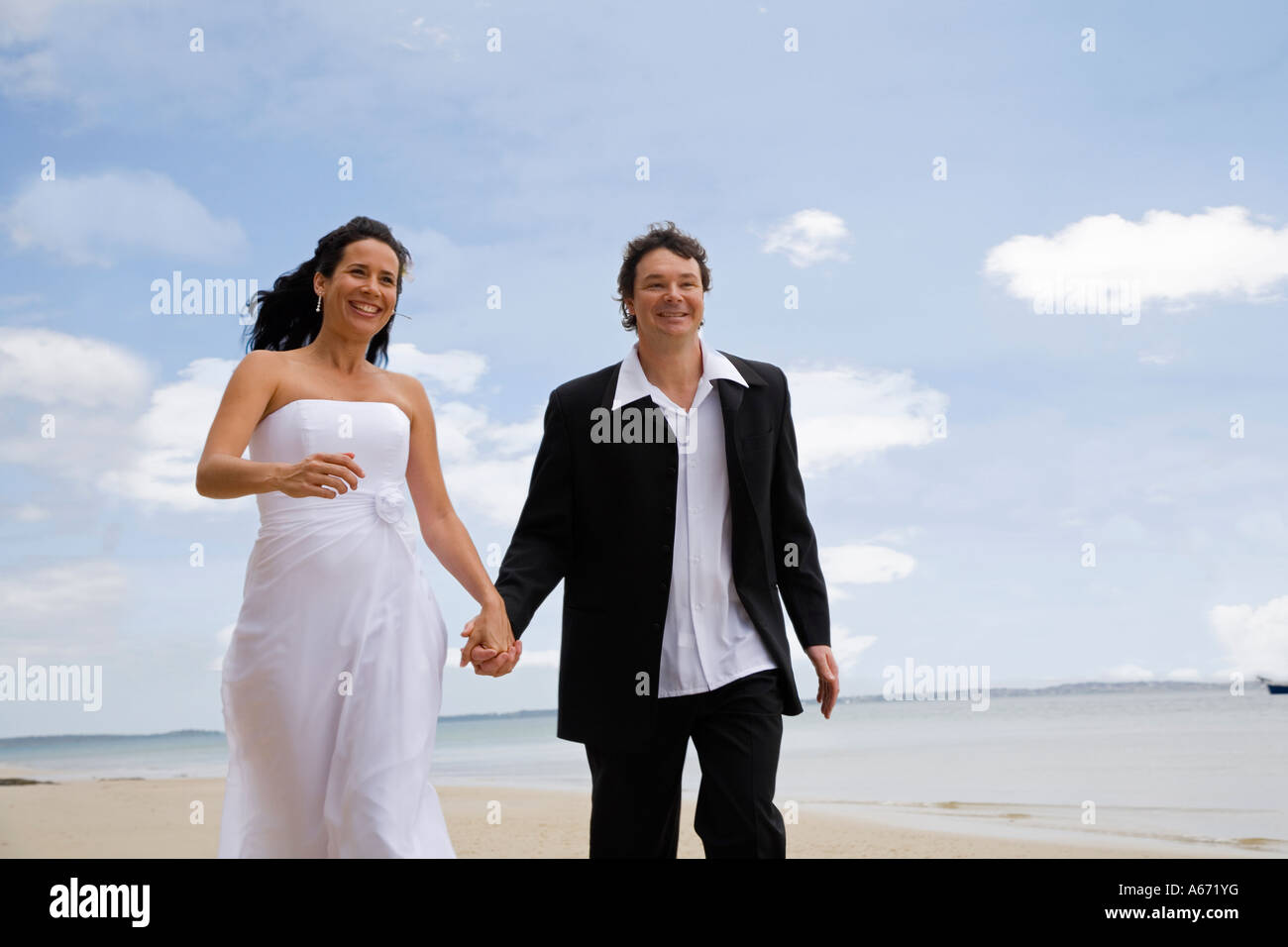 A happy couple walk along Sunset Beach at Kingfisher Bay on Fraser ...