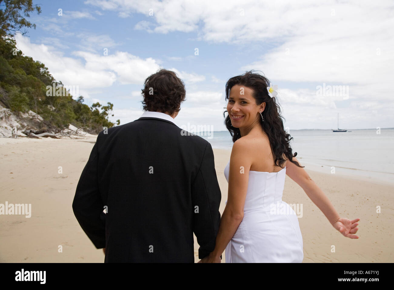 A happy couple walk along Sunset Beach at Kingfisher Bay on Fraser ...