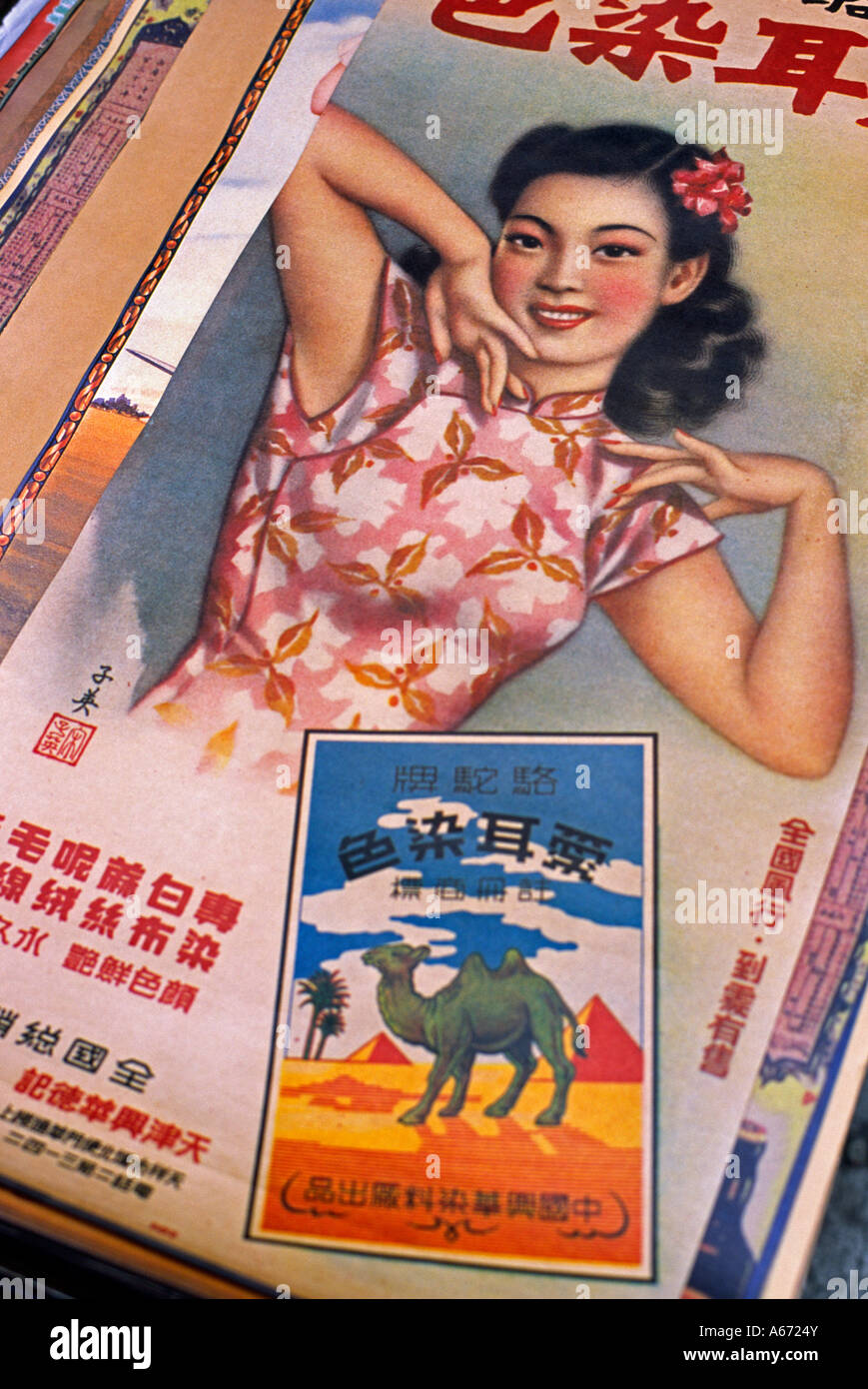 A vintage poster for exotic travel sits amongst antiques and curios in the Cat Street Market in Sheung Wan district Hong Kong Stock Photo