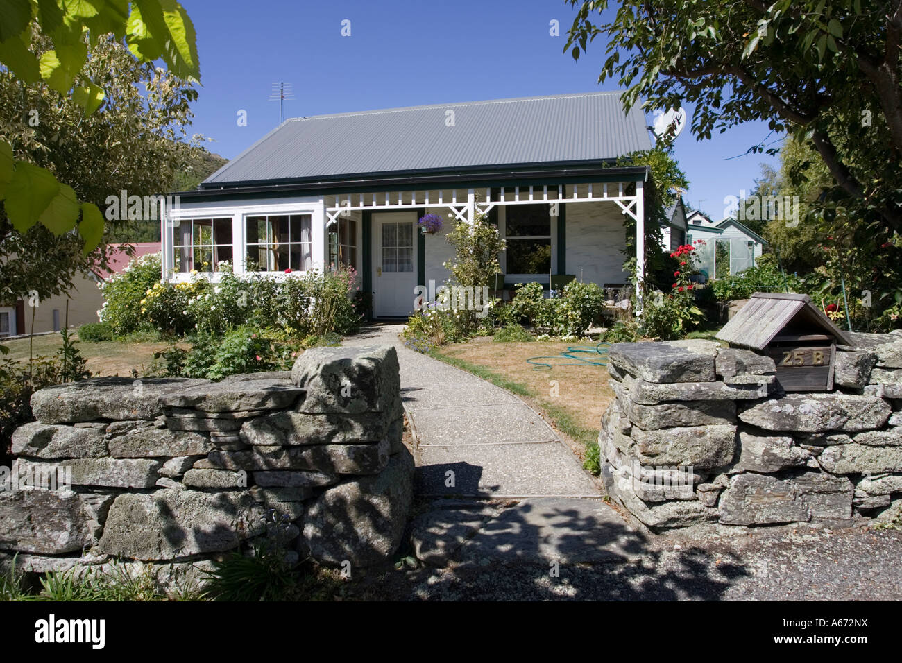 Small cottage with flower garden in former goldrush town of Arrowtown near Queenstown New Zealand Stock Photo