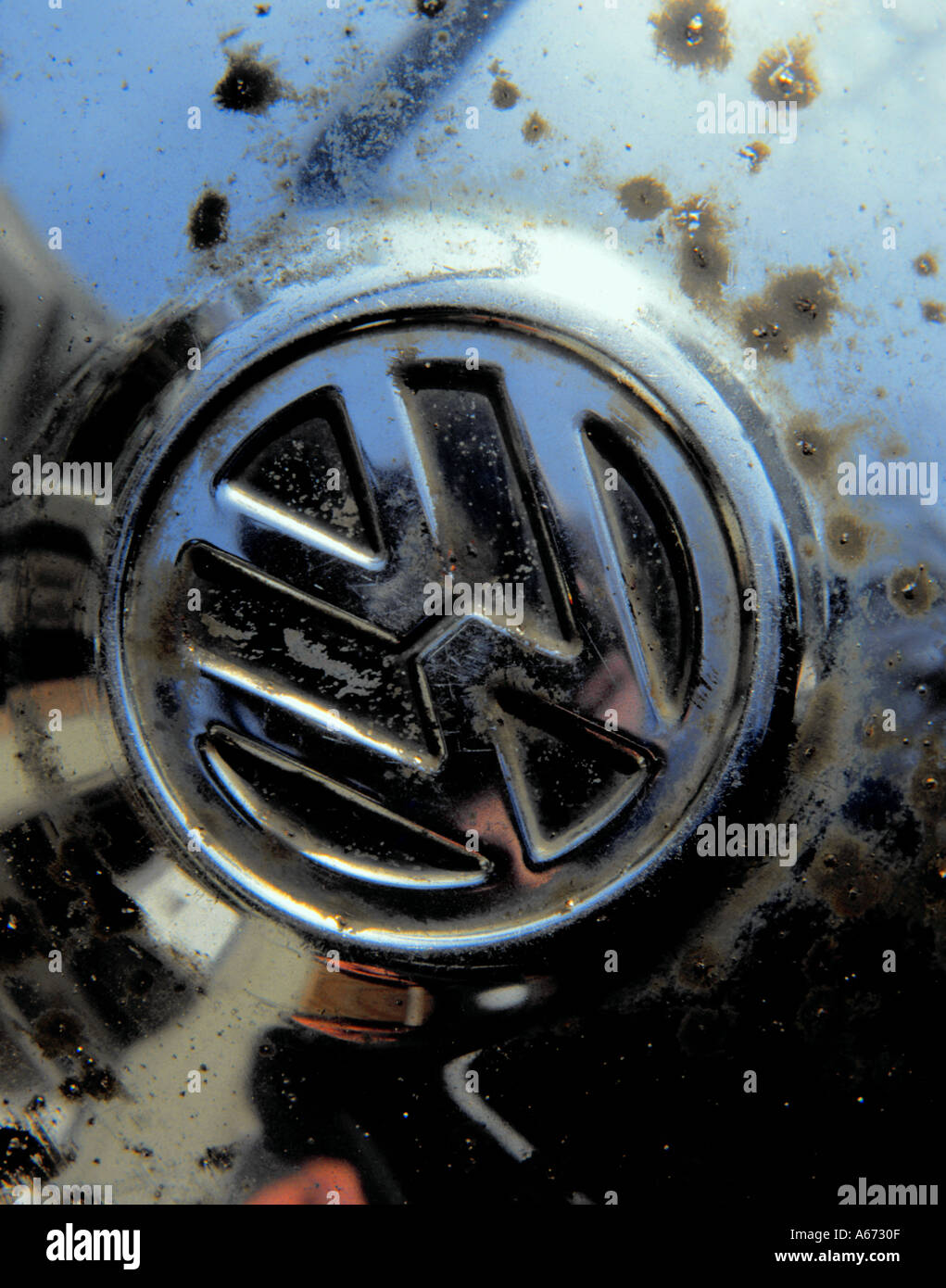 Corrosion of steel hub cap where surface chromium plate coating has been chipped by road grit. Stock Photo