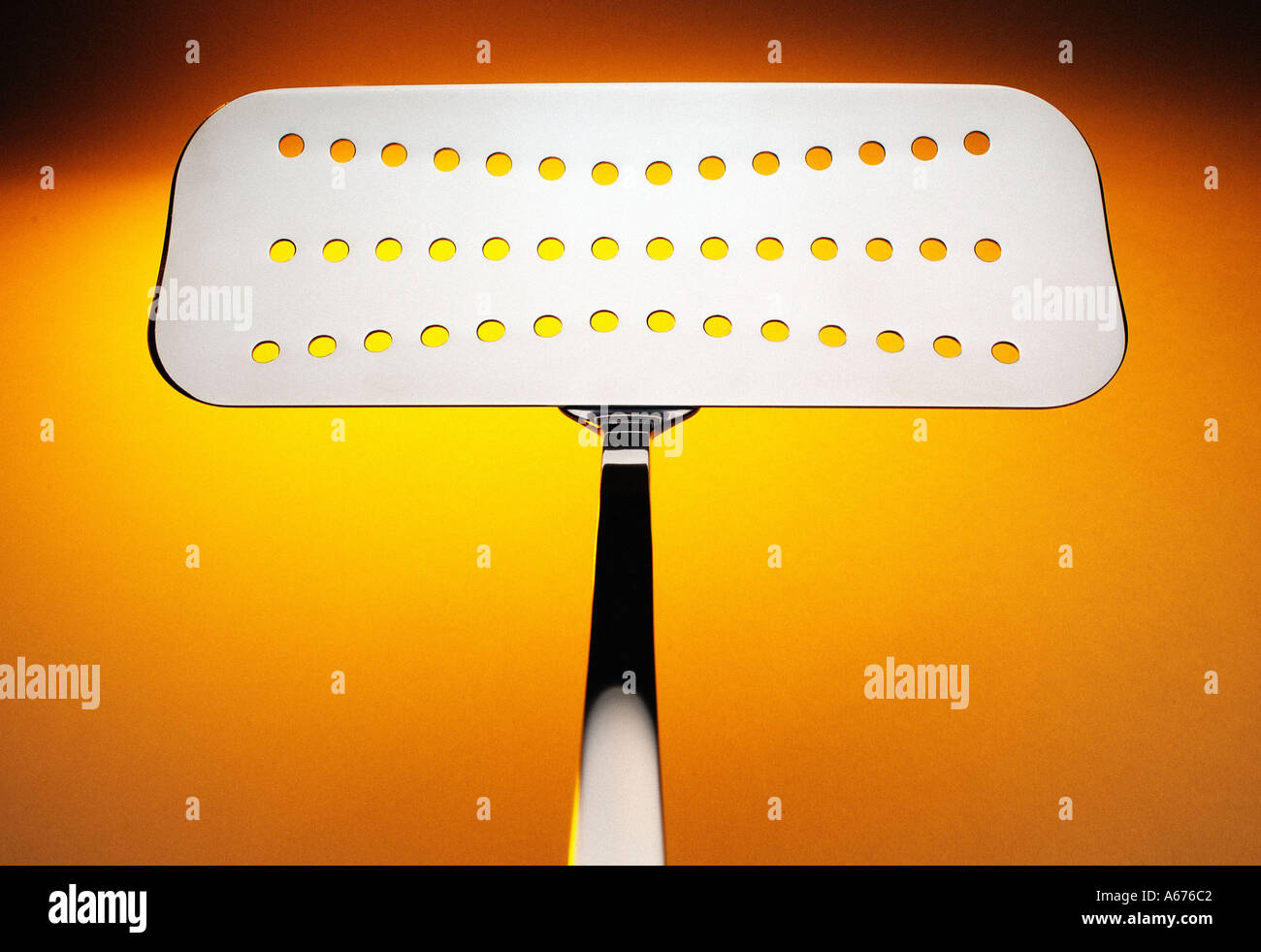 Stainless steel fishslice on orange and yellow background Stock Photo