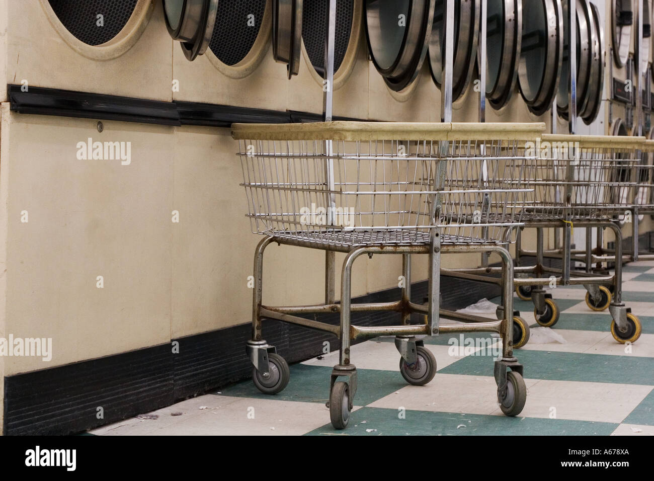 Dryers and clothes carts at laundromat Stock Photo - Alamy