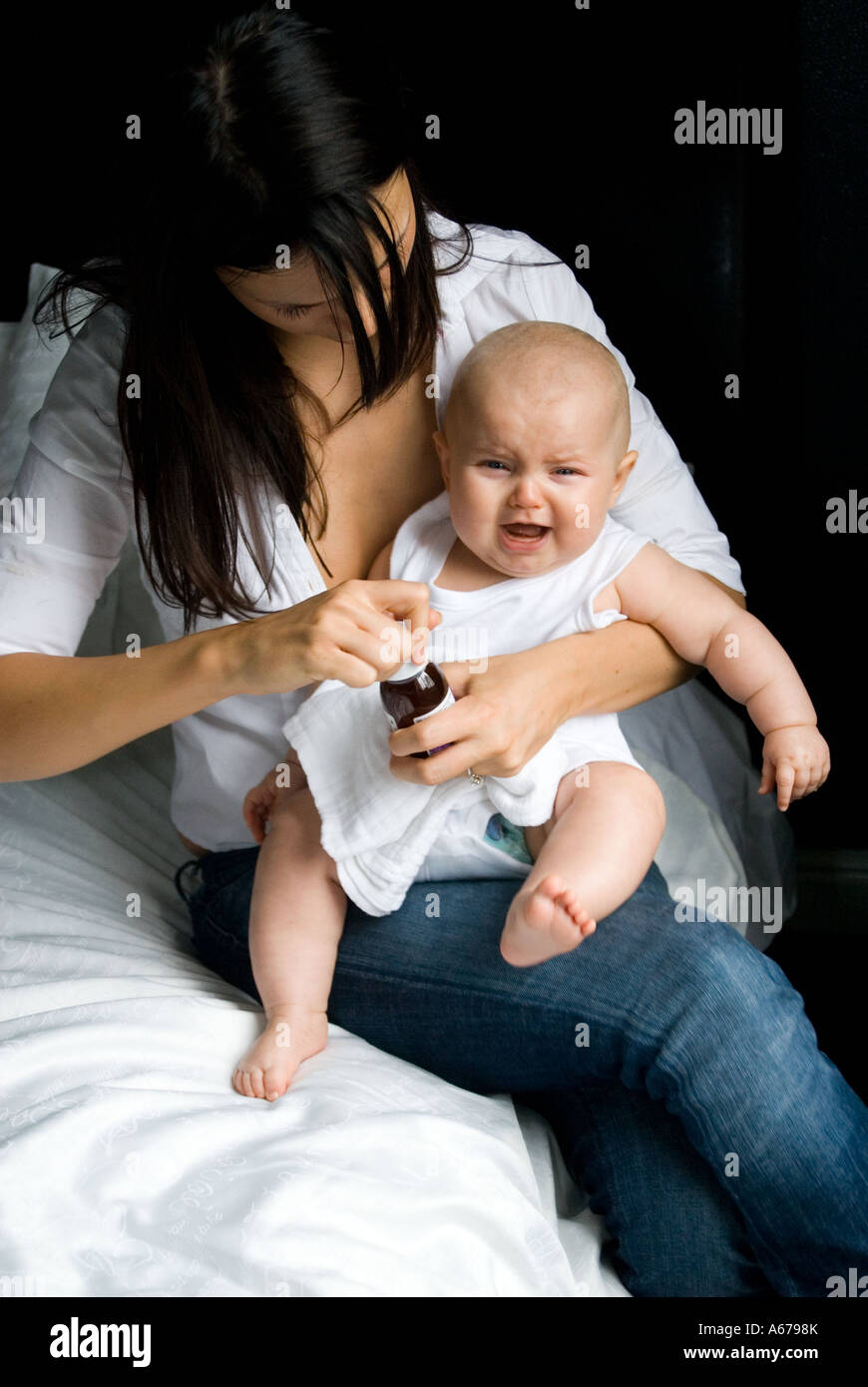Mother gives baby medicine Stock Photo Alamy