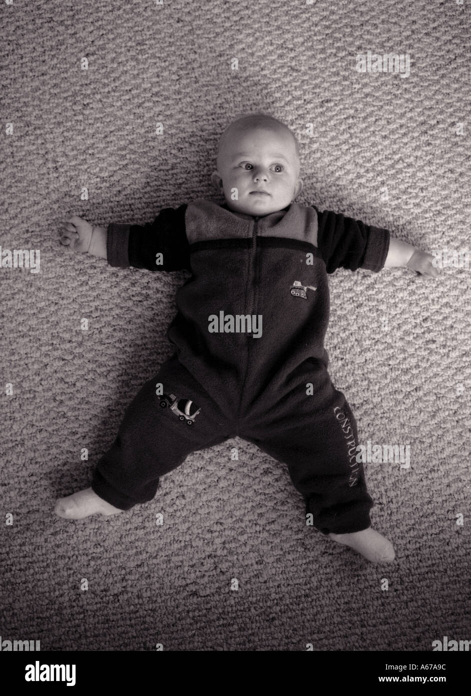 Baby boy laying on floor looking strait up Stock Photo
