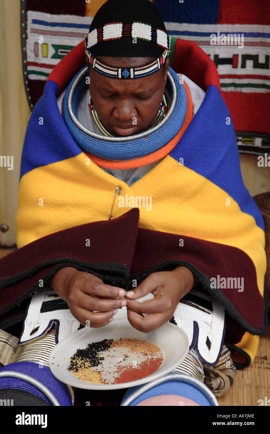 Ndebele woman in traditional clothing making bead necklace South Africa Stock Photo