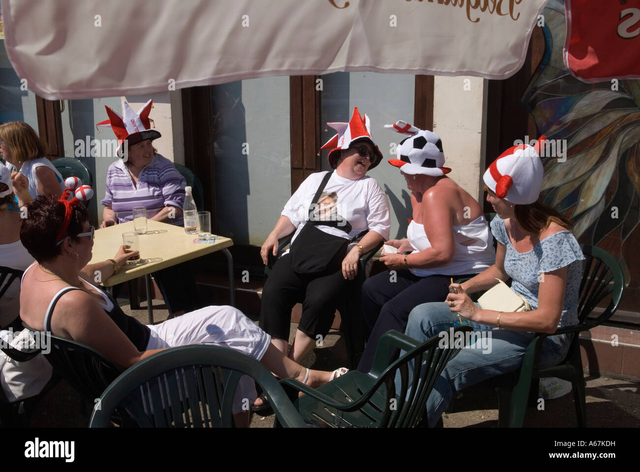 Hen party group 2000s UK Senior lady world cup football fans wearing traditional funny England hats drinking outside a pub. Southend on Sea Essex 2006 Stock Photo