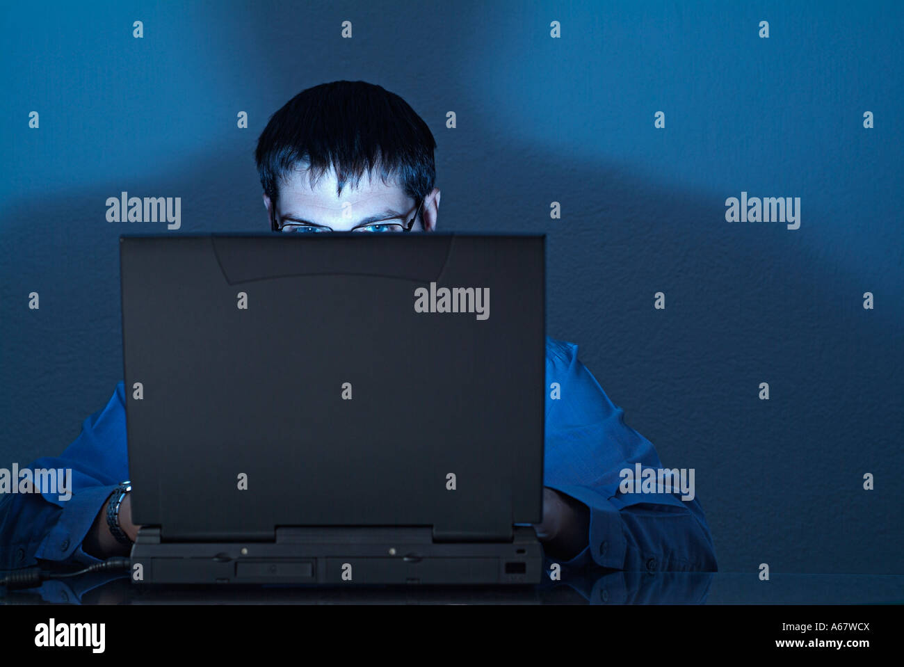 Businessman Using Laptop Working Late Into the Night Stock Photo