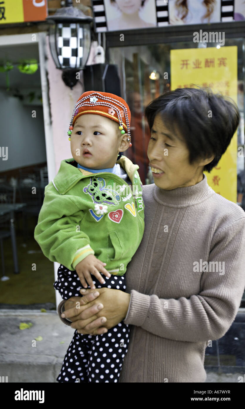 CHINA BEIJING Chinese mother holding her traditionally dressed infant ...