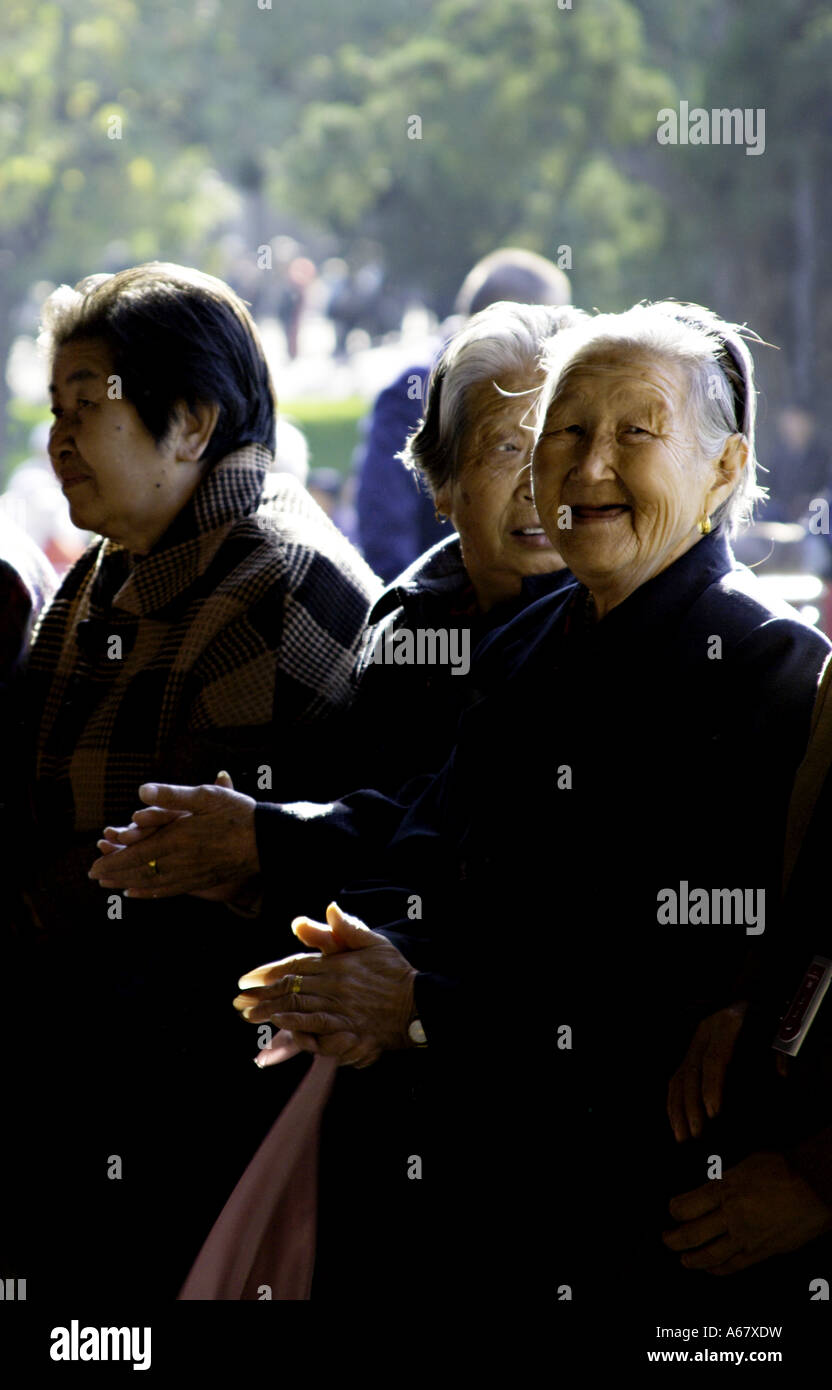 CHINA BEIJING Elderly Chinese woman smiling happily at the photographer and clapping Stock Photo