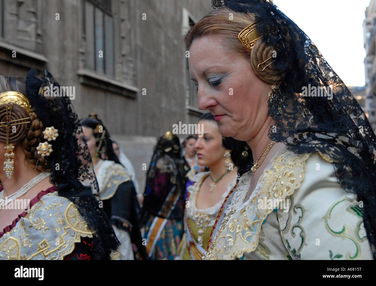 Falleras in traditional Valencian costume marching in the street during ...