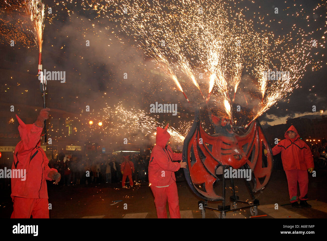 Falleros in red costume marching with sparklers during Cavalcada del ...
