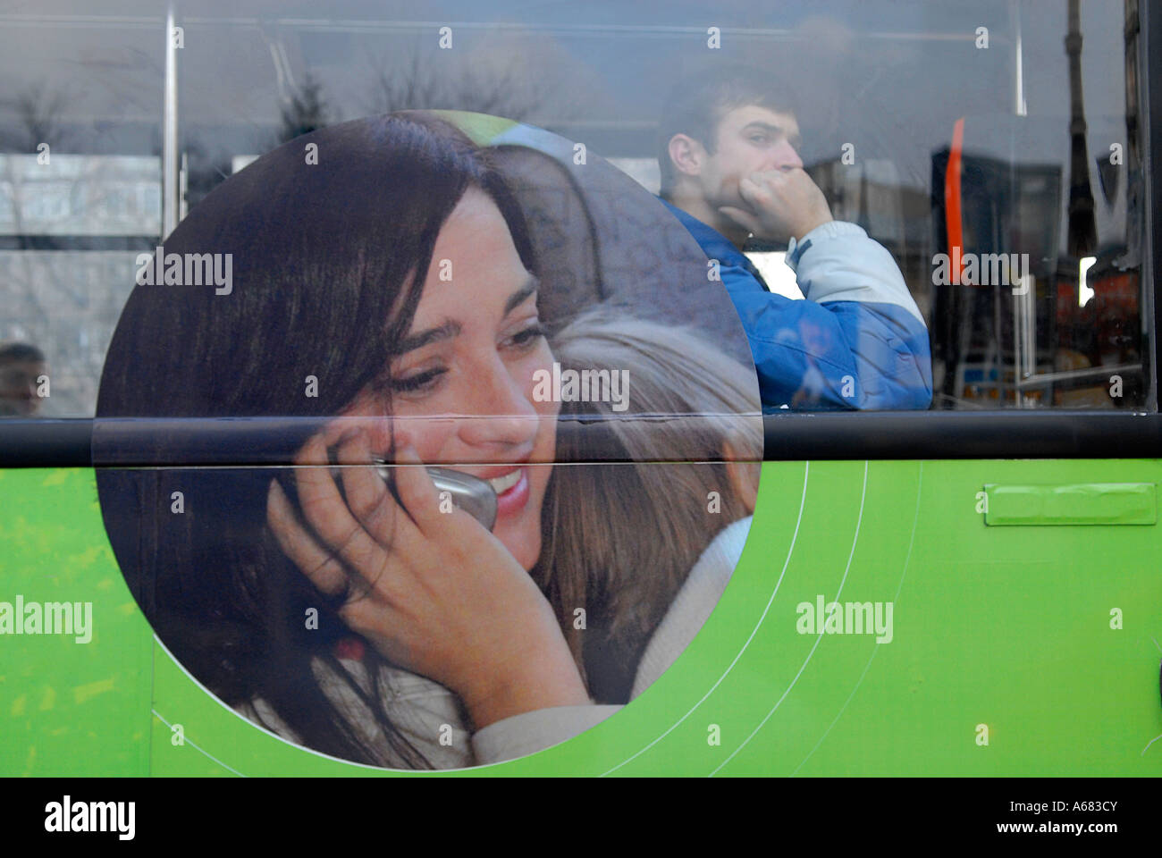 A passenger siting in a bus advertising cellular phone company in the city of Bucharest in Romania. Stock Photo