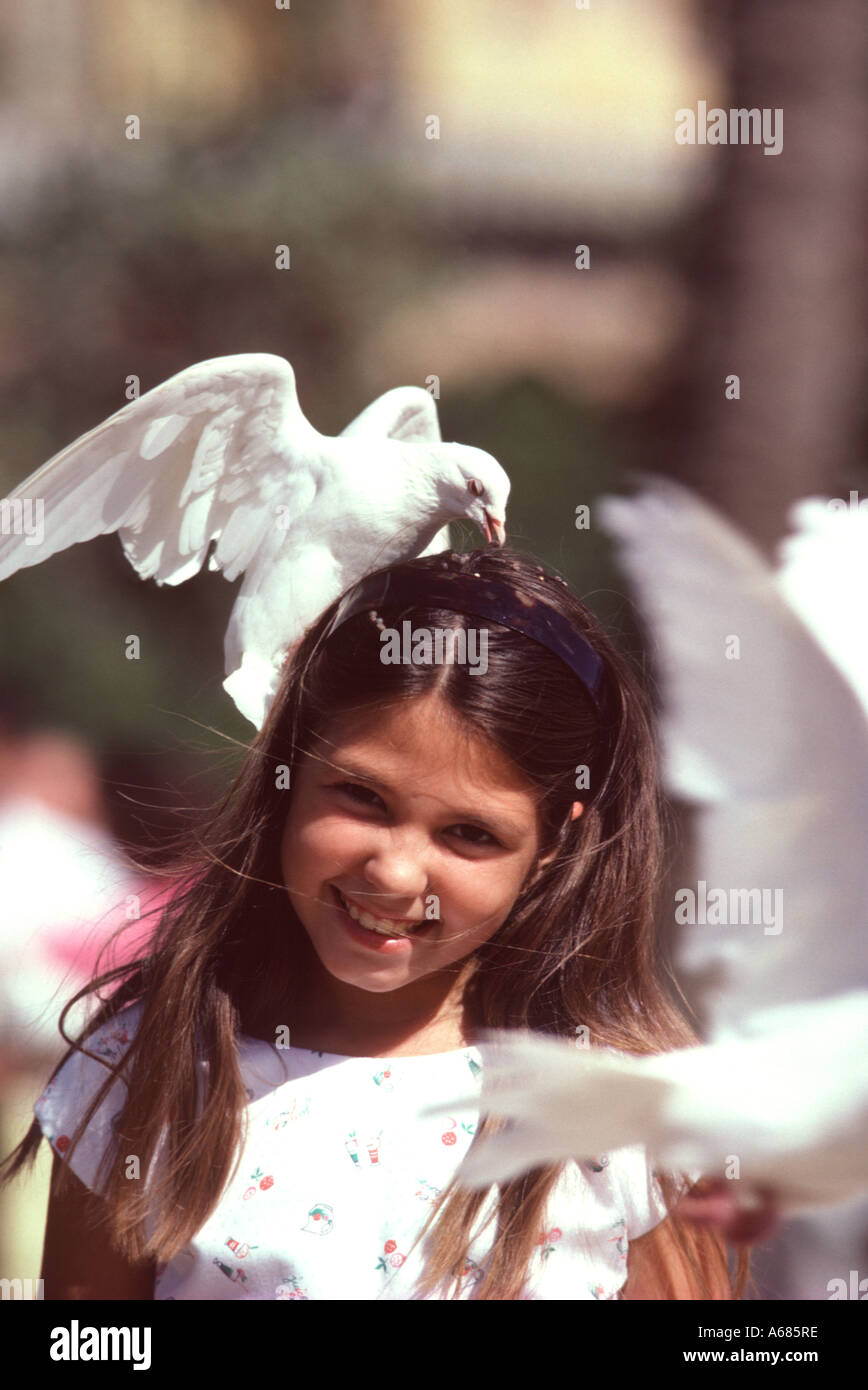 Spain Andalusia Seville Young girl enjoying the famous white pigeons of Seville Stock Photo