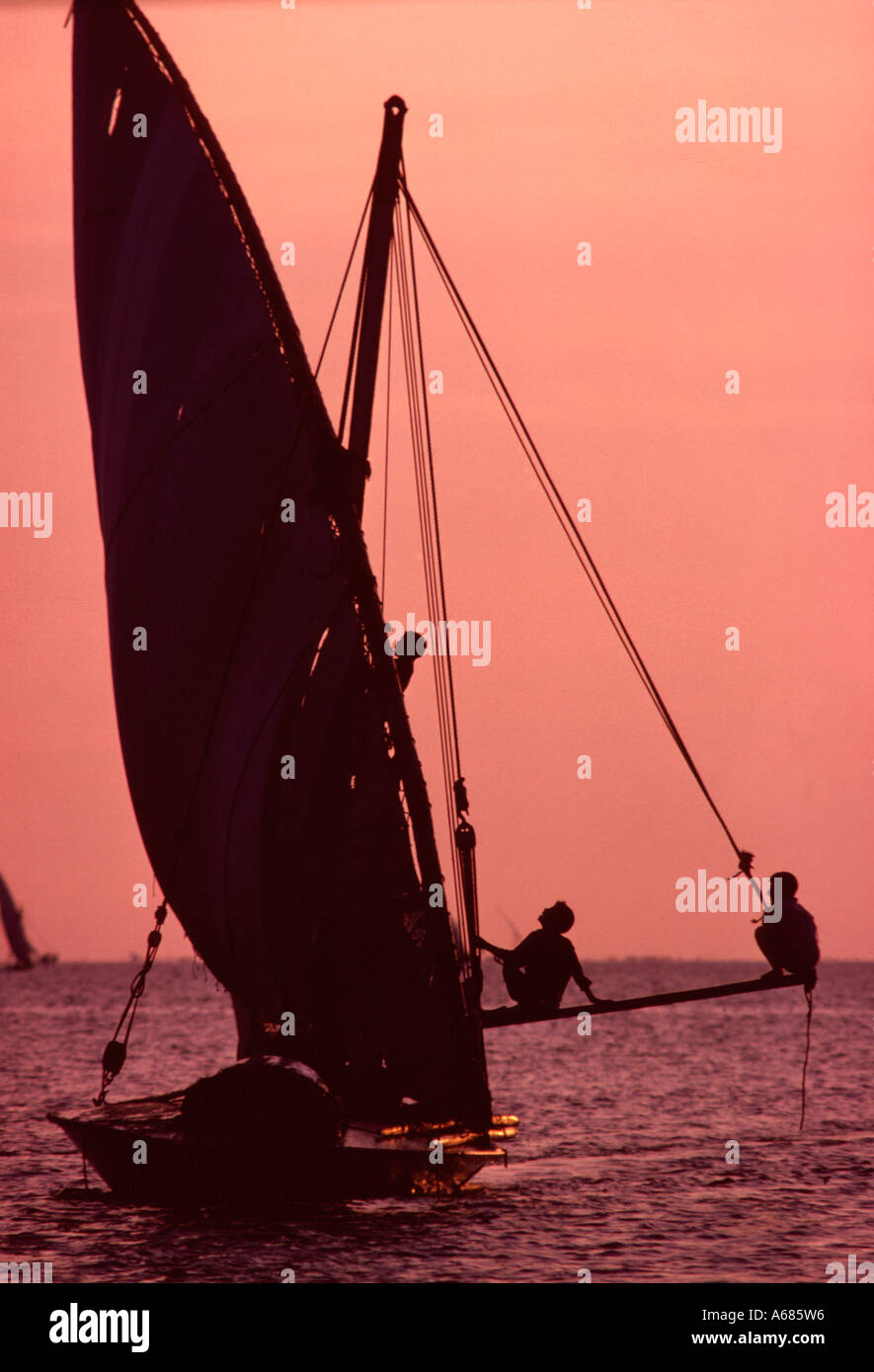 Egypt. Lake Manzala in Nile Delta just inland from the Mediterranean. Fishing boat with boy on a boom balancing against the wind Stock Photo