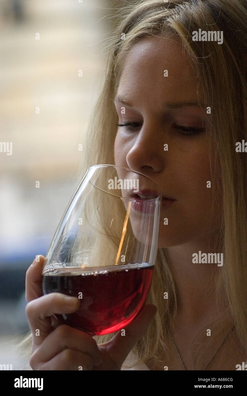 Blonde girl drinkinf a glass of red wine Stock Photo - Alamy