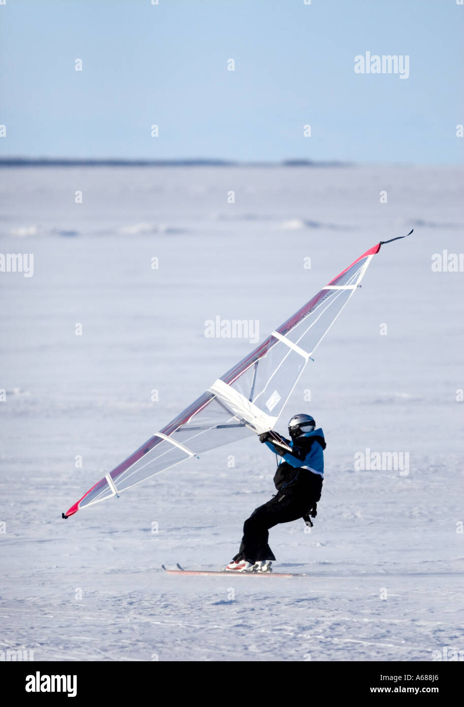 Man skiing on sea ice at Wintertime using a kitewing, Finland Stock Photo