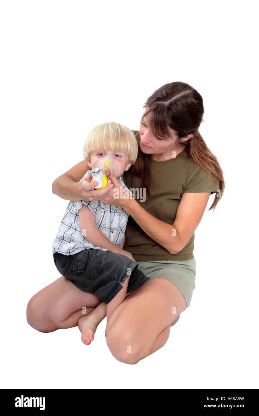 Young mother giving respiratory medicine to her son with bronchitis or chest problems Stock Photo