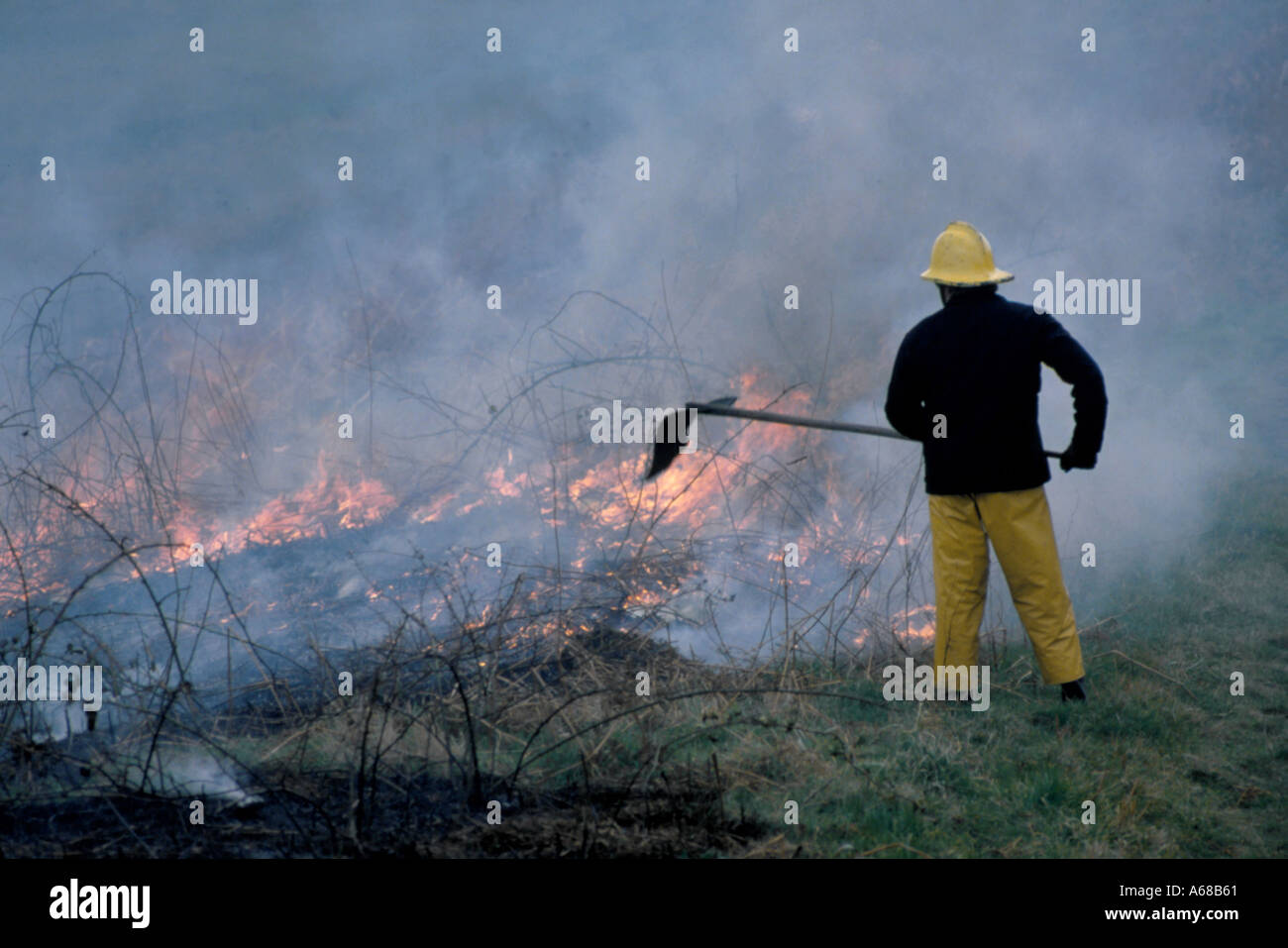 Fireman dealing with a heath fire, Alnmouth, Northumberland, England, UK. Stock Photo