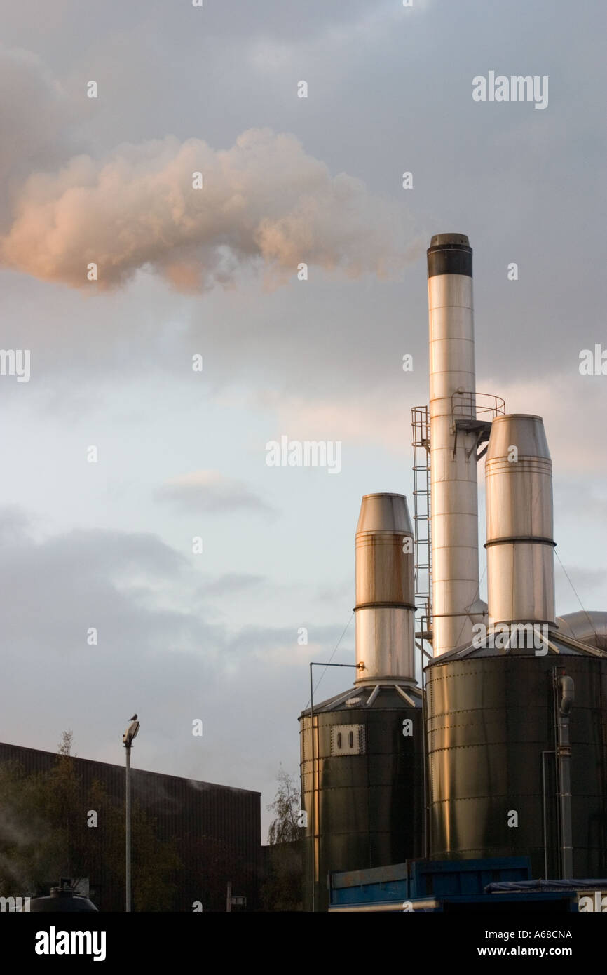 Chimney at Bradford factory belching out steam in early morning sun Stock Photo
