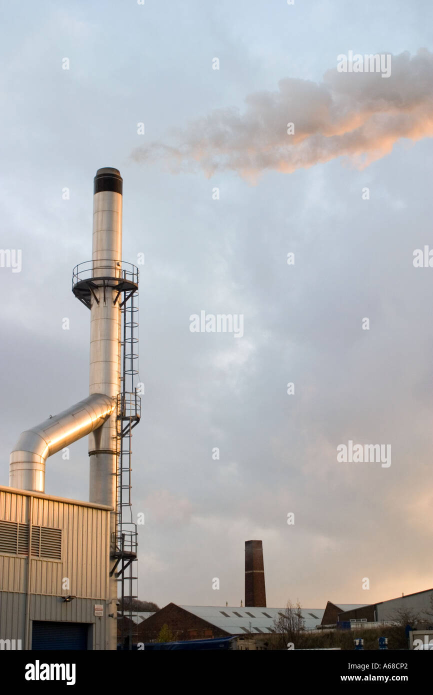 Chimney at Bradford factory belching out steam in early morning sun Stock Photo