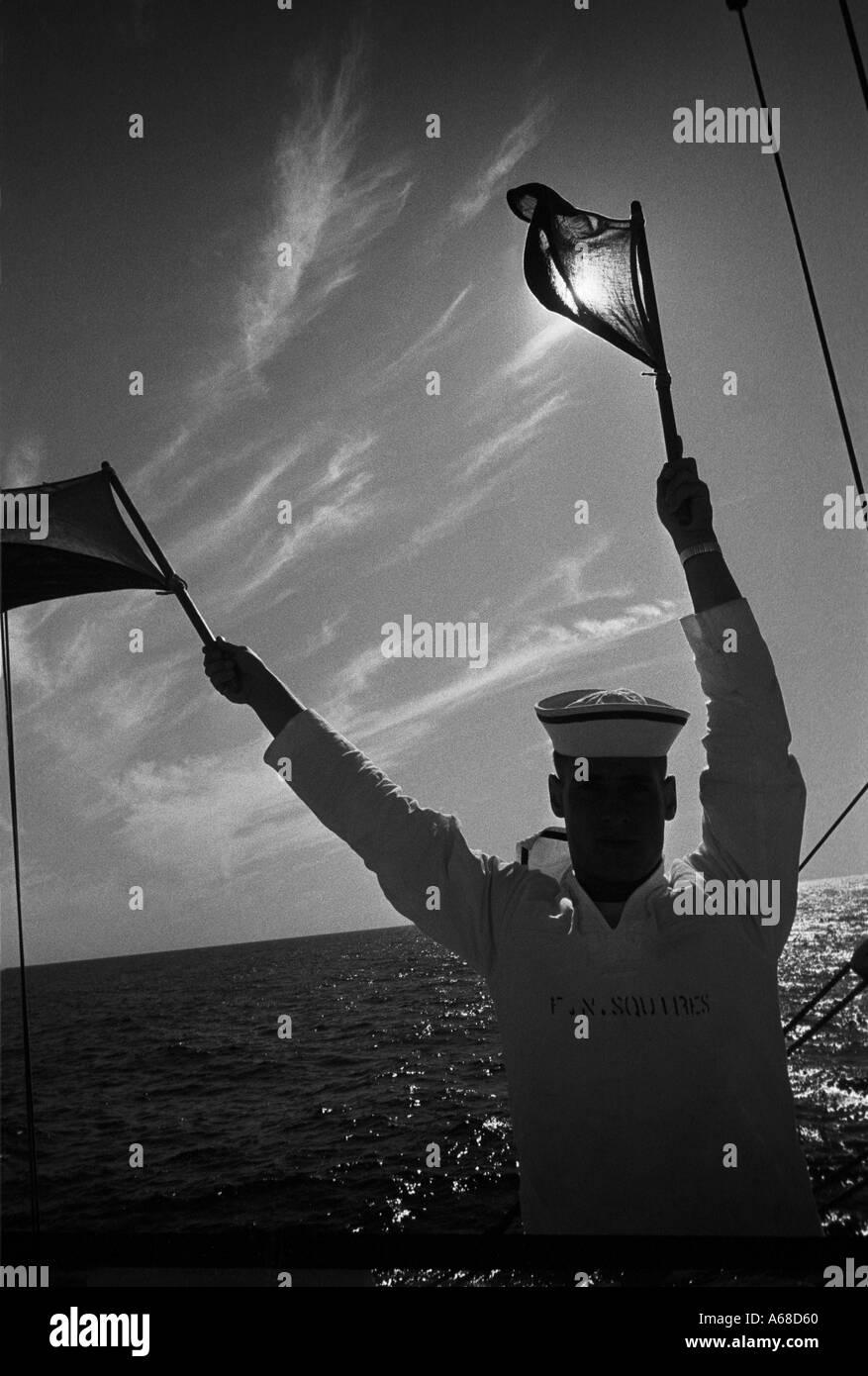 A cadet from the United States Coast Guard Academy practices with signal flags while on the USCG Eagle  Stock Photo