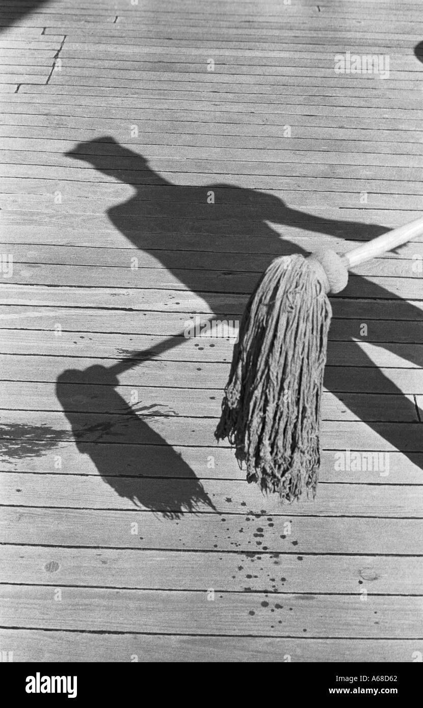 Shadow of a cadet from the United States Coast Guard Academy swabing the deck of the USCG Eagle  Stock Photo