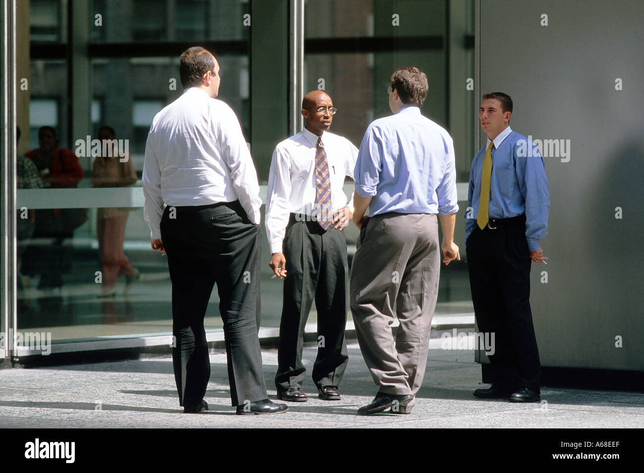 Office workers standing outside for a cigarette break in Manhattan financial district Stock Photo