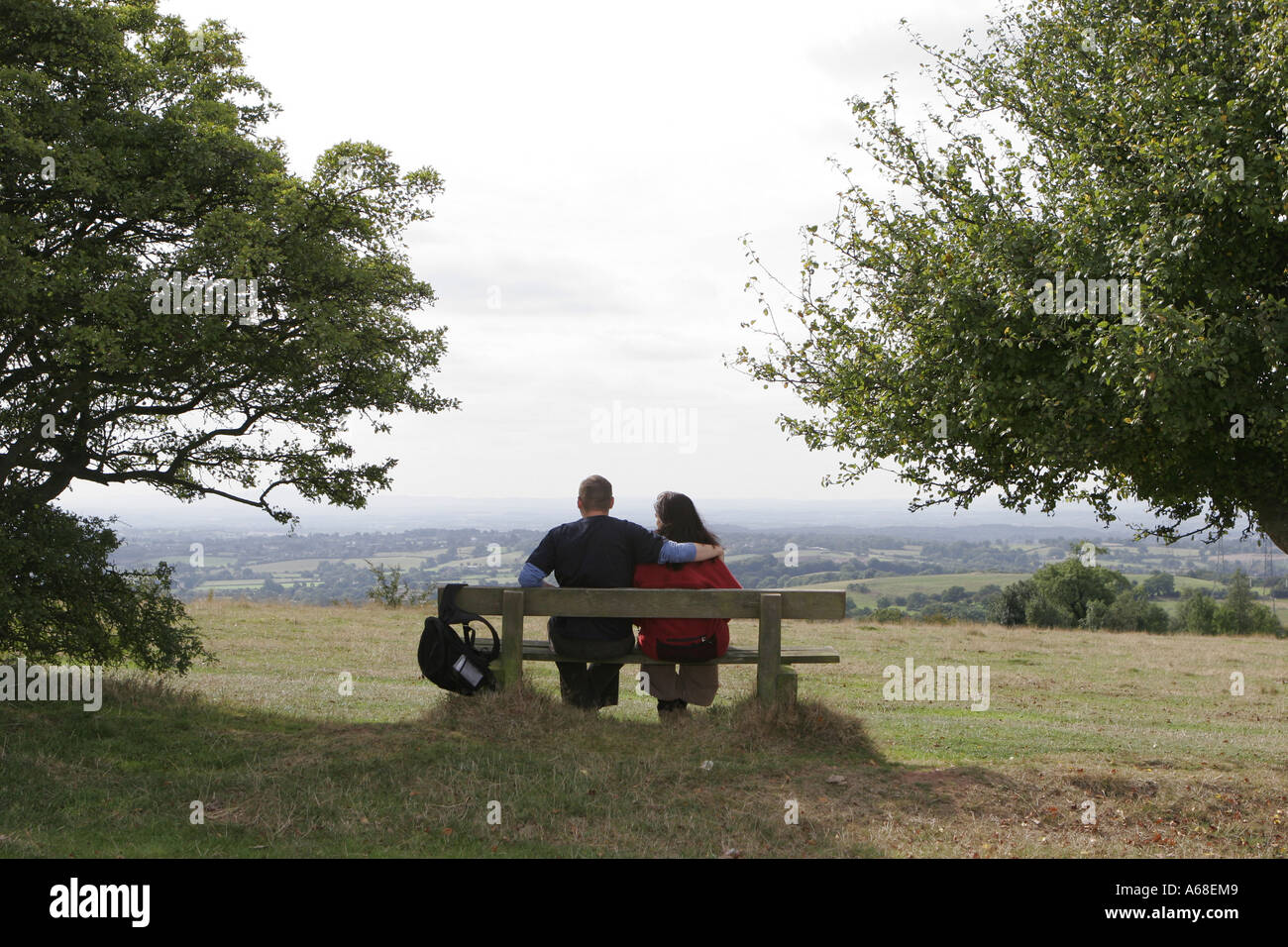 Couple sitting on a bench along a country path Stock Photo - Alamy