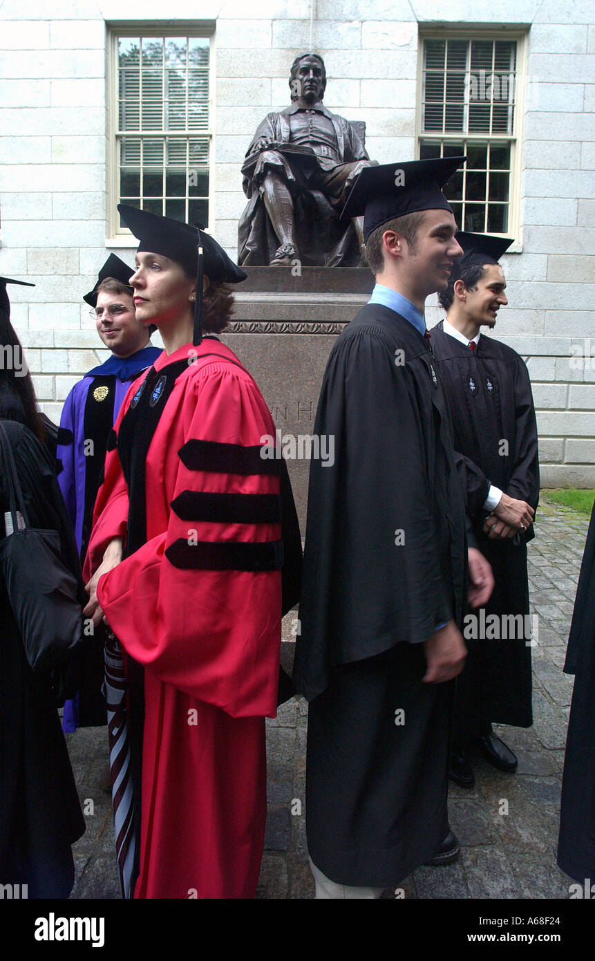 Harvard professors and students stand in front of the statue of John