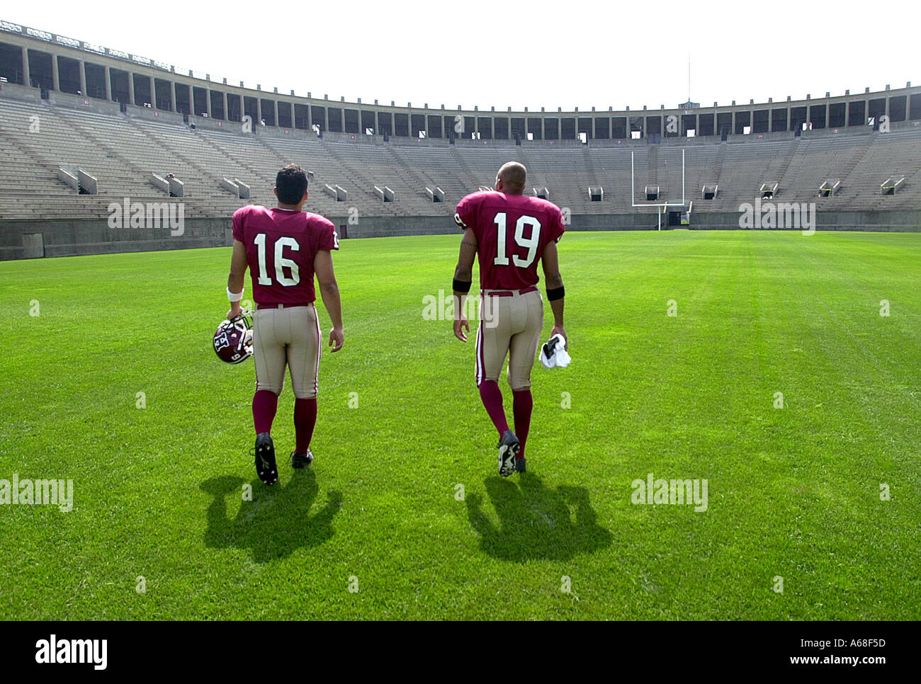 Two Harvard football players walk in an empty Harvard stadium Cambridge Massachusetts Stock Photo