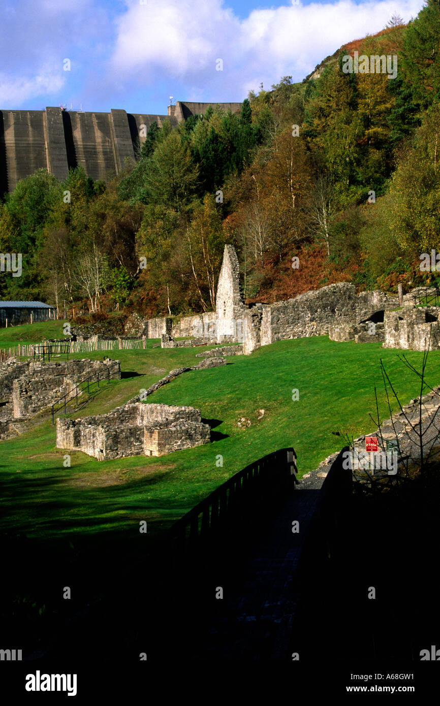 The Clywedog Dam towers above the preserved ruins of the Bryntail lead mine. Powys, Wales, UK. Stock Photo