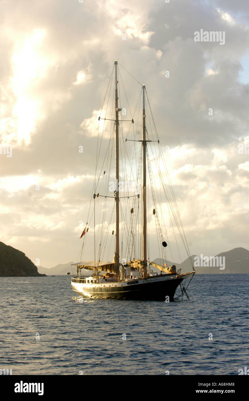 British Virgin Islands Caribbean Old sail boat anchored in a bay at sunset Stock Photo