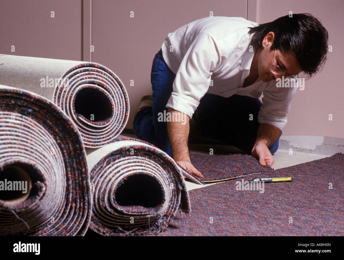 Man installing wall to wall carpet Stock Photo