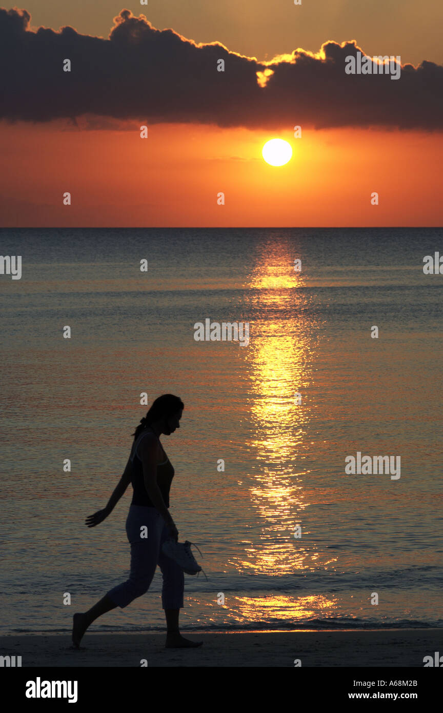 woman walking on beach at sunset Stock Photo - Alamy