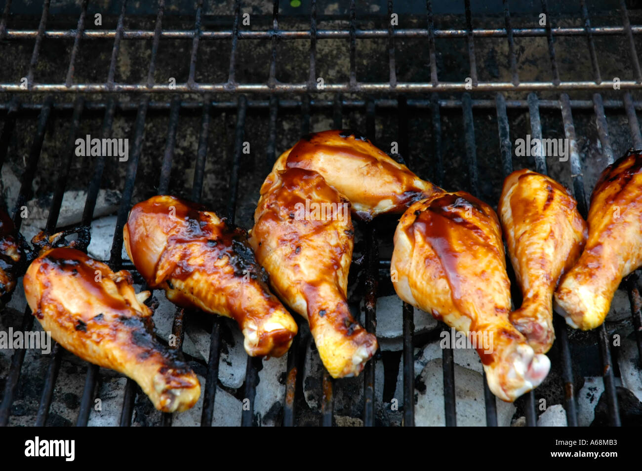 Barbecue chicken legs being cooked on a charcoal grill Stock Photo Alamy