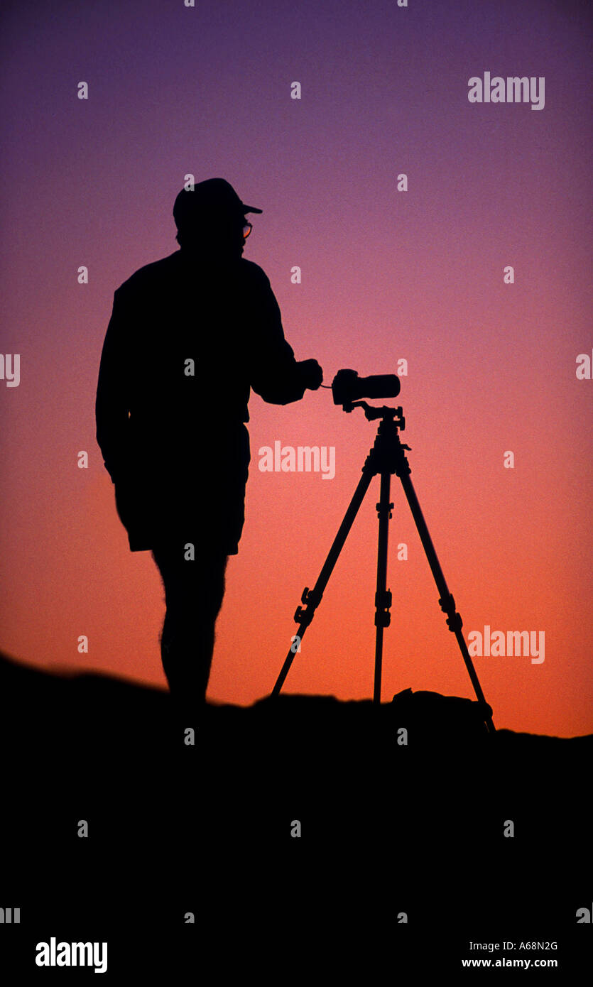 A photographer and camera tripod in silhouette at dawn Stock Photo - Alamy