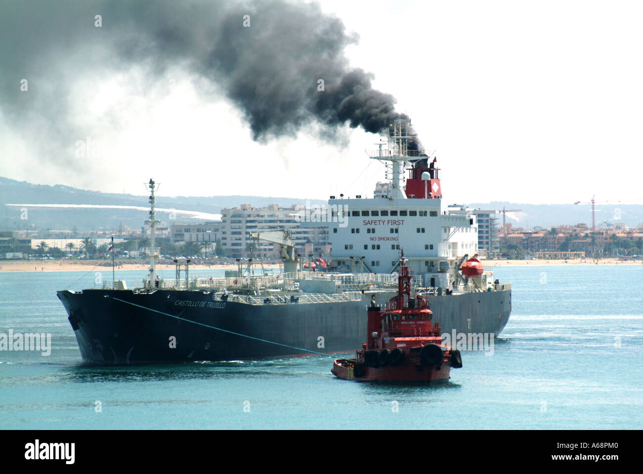 Black smoke & soot emissions belching out  from cargo ship funnel polluting local atmosphere & environment arriving at Port of Palma Mallorca Spain EU Stock Photo