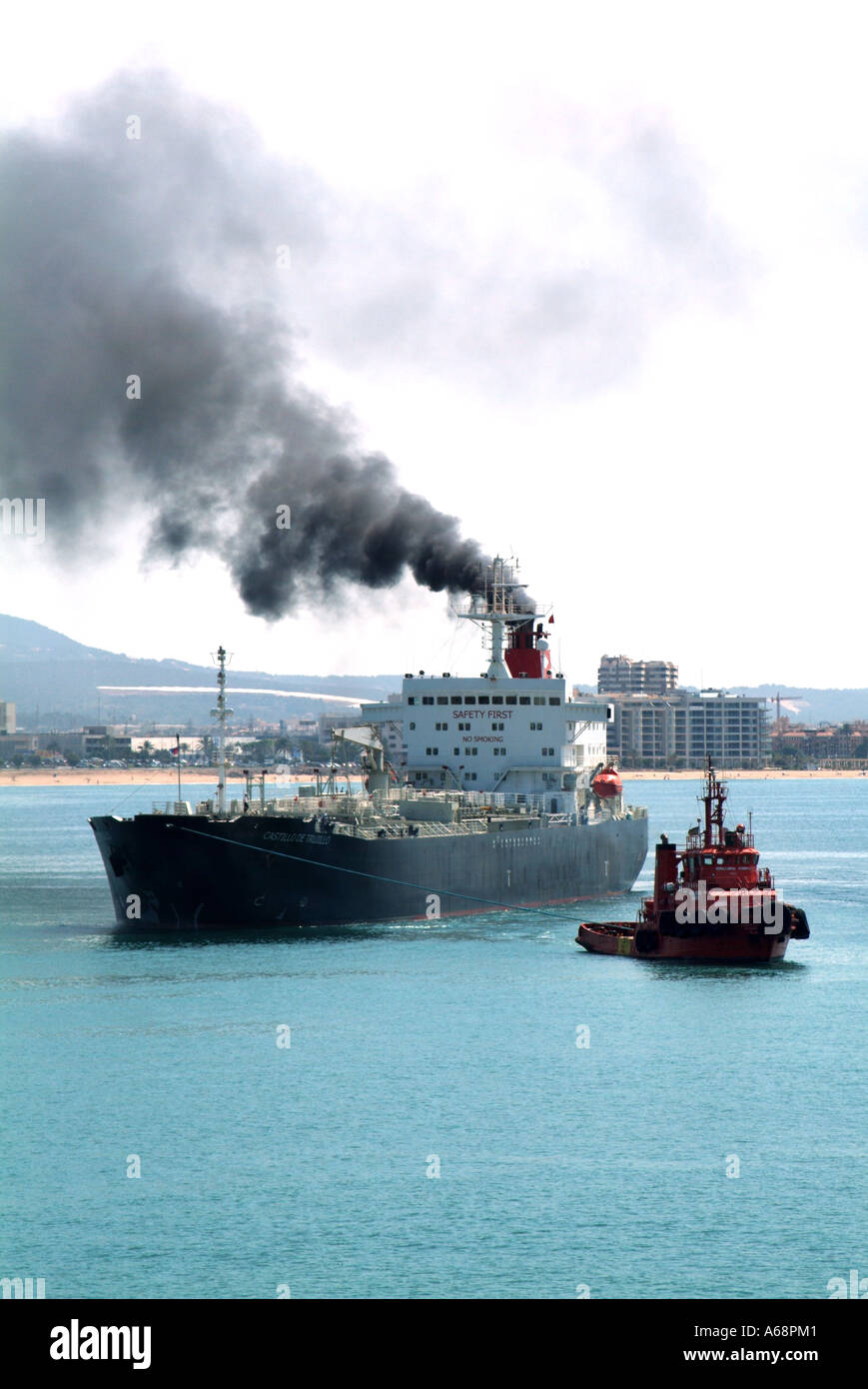 Back smoke & soot emissions belching out from funnel Cargo ship polluting local atmosphere & environment arriving at Port of Palma Mallorca Spain EU Stock Photo